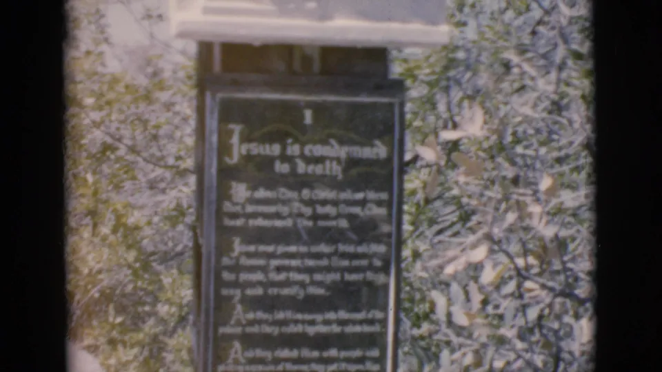1966 Clarkdale, Arizona 8mm frame showing a religious plaque headed Jesus is condemned to death in an outdoor setting.