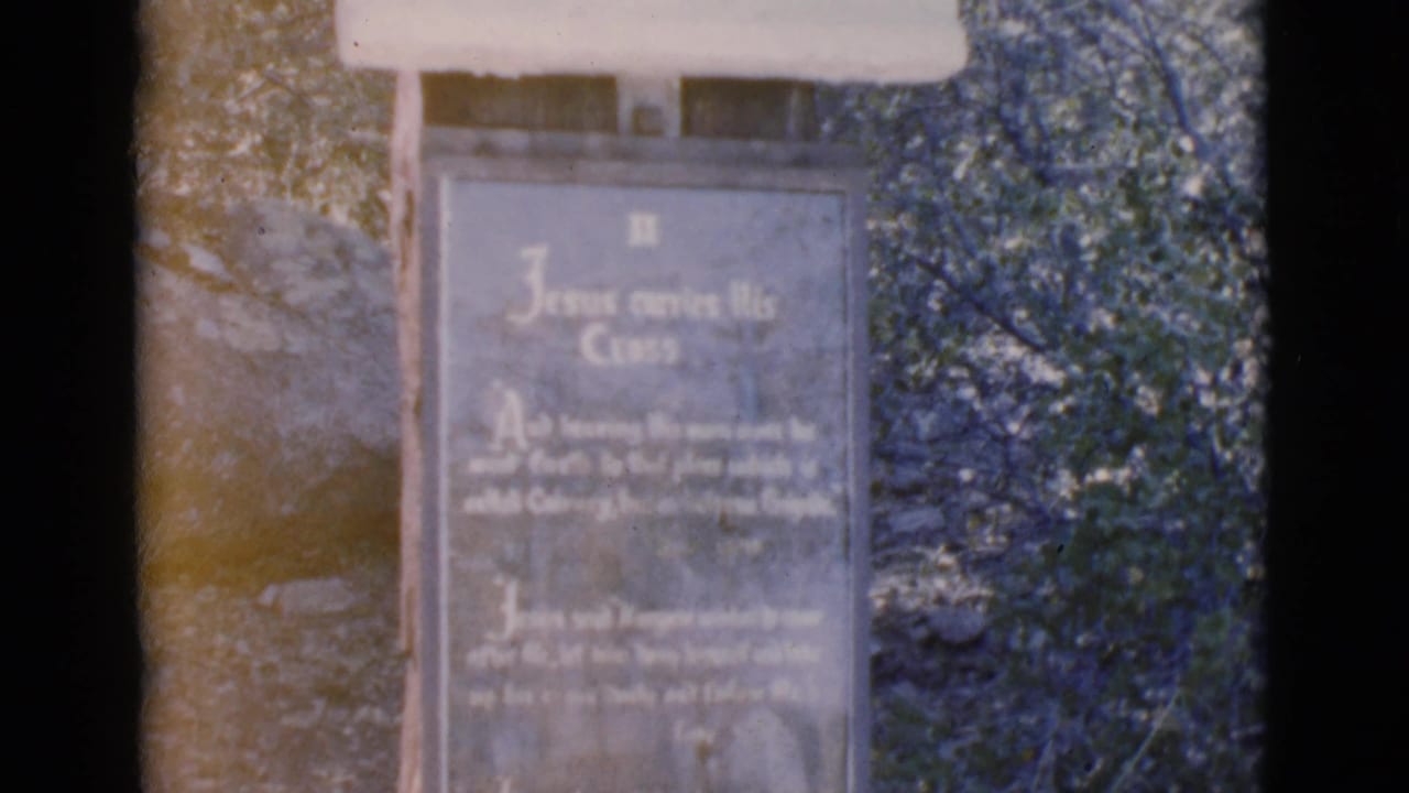 Closer view of the same outdoor inscription marker, with trees and rocks behind it.