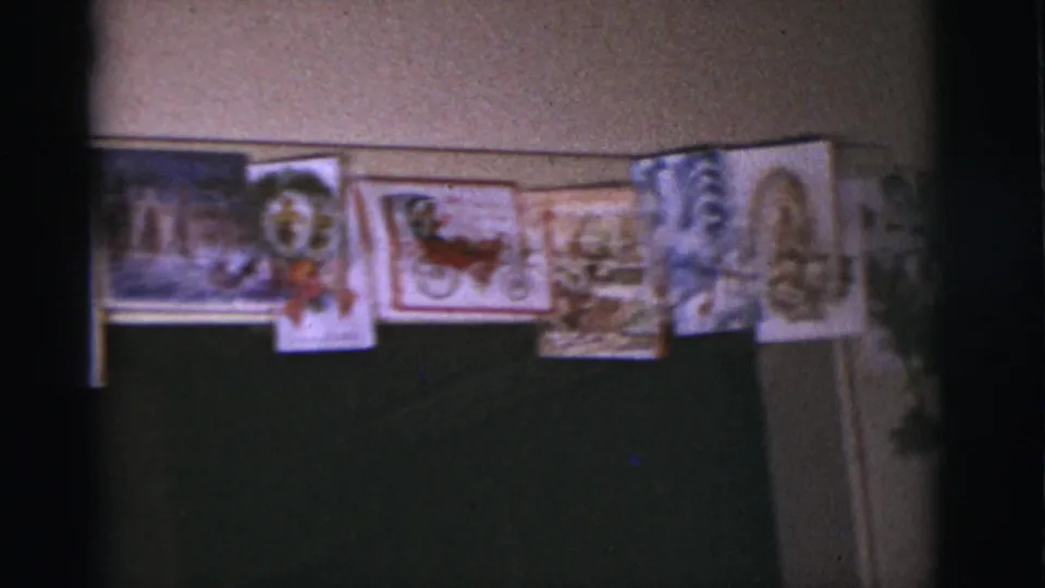 1966 Tuscon home interior showing a line of Christmas postcards or cards, including holiday scenes and a red sleigh motif.