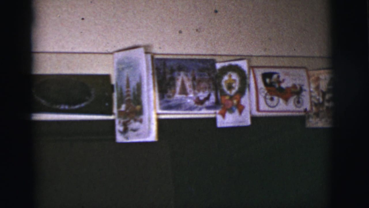 Christmas cards mounted along an interior wall above a dark horizontal panel.