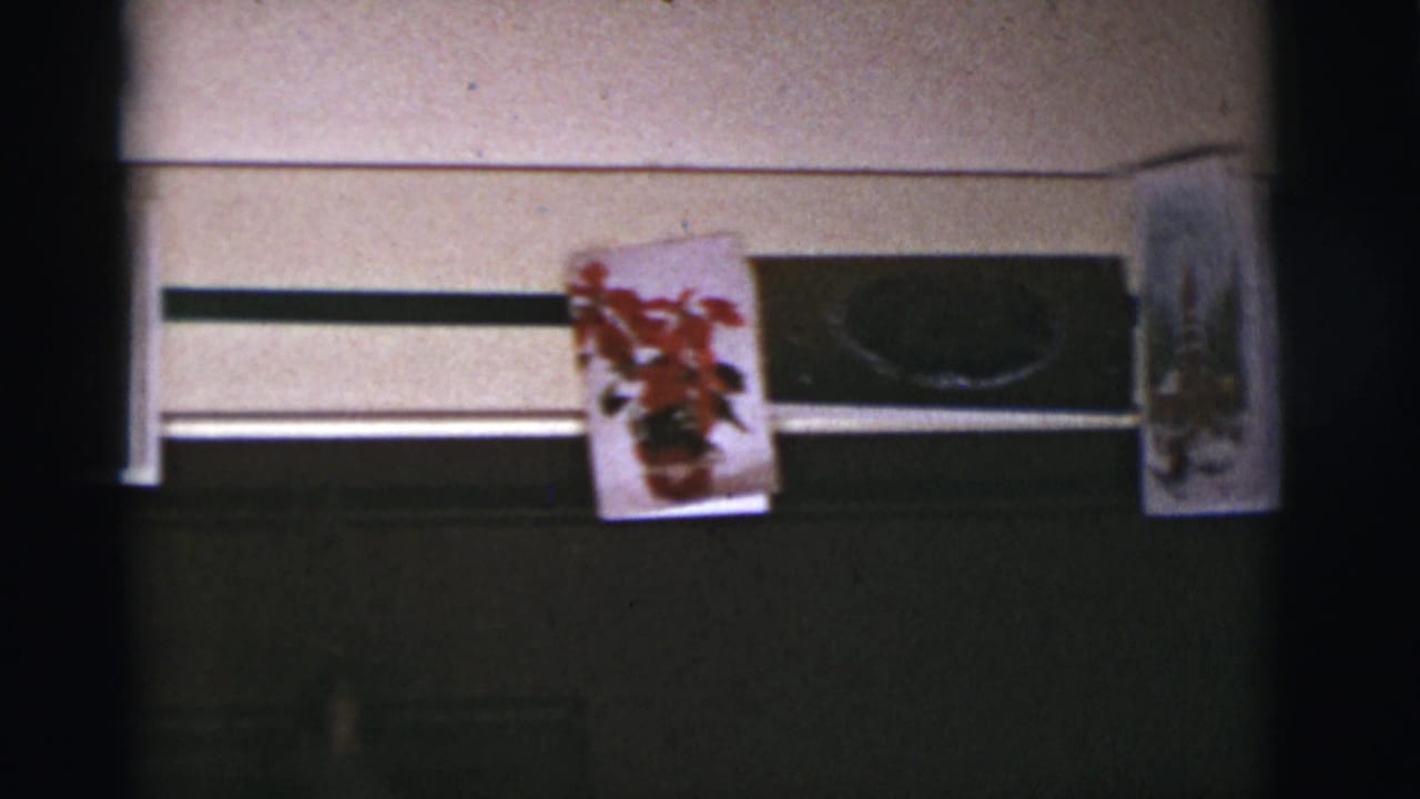Poinsettia card and holiday cards mounted above a dark window or panel.