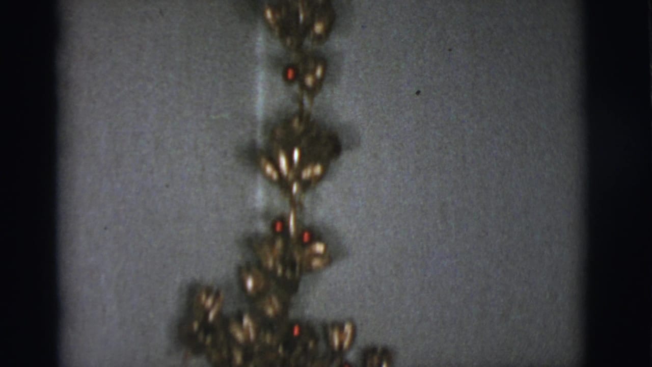 Gold hanging ornaments against a plain interior wall.
