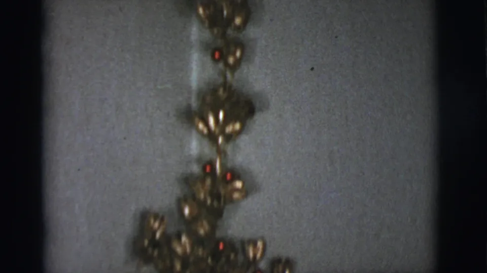 Gold holiday ornaments hang against a wall in this 1966 Tucson domestic Christmas interior.