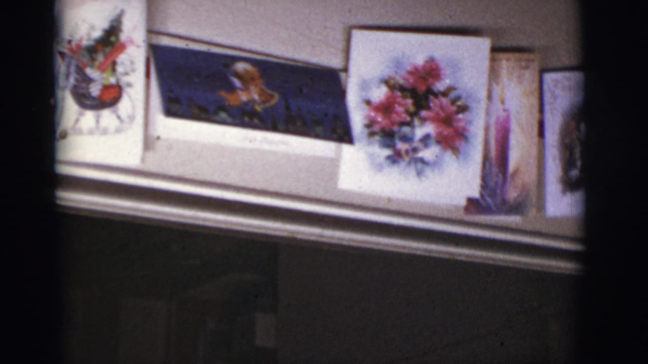 Christmas cards displayed along a mantel inside a dim room.