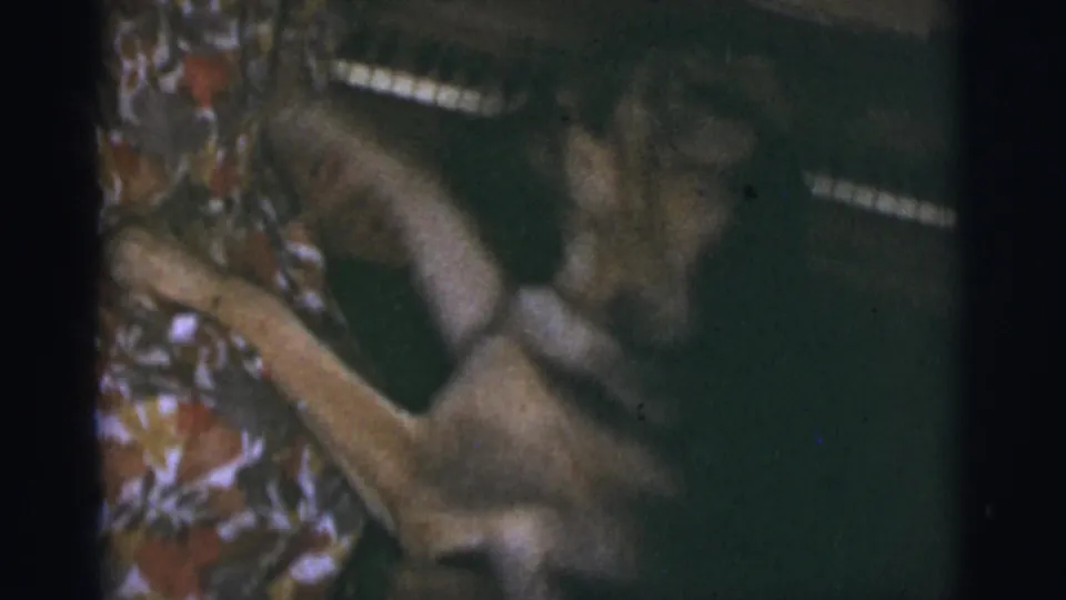 A German Shepherd lounges near an upright piano in 1966 Tuscon, Arizona home-movie footage.