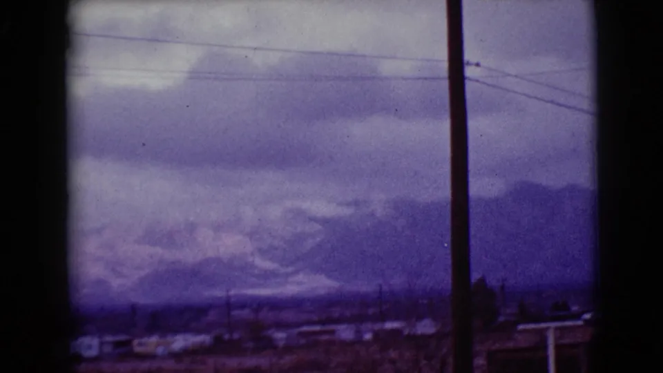 1968 Clarksdale, Arizona frame with purple color shift, overcast sky, distant mountains, power lines, and a foreground pole.