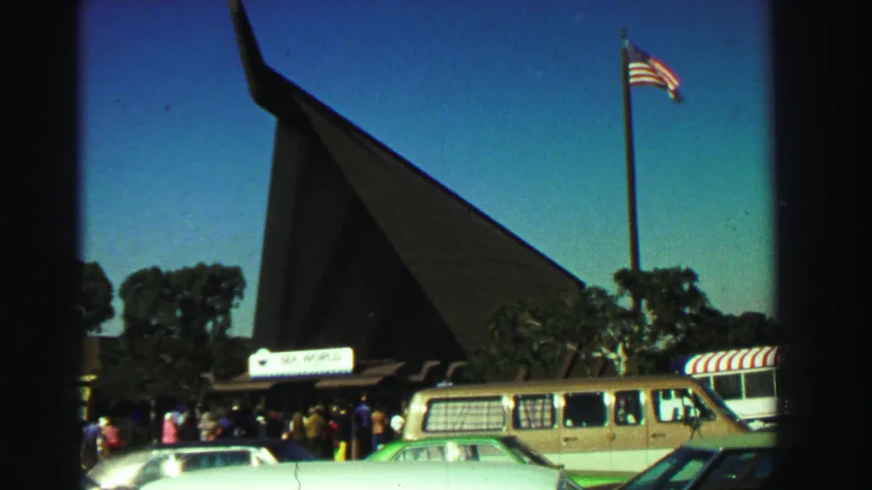 1969 Reno home-movie view of the Sea World entrance, with visitors gathered below a tall flagpole and pointed-roof structure.