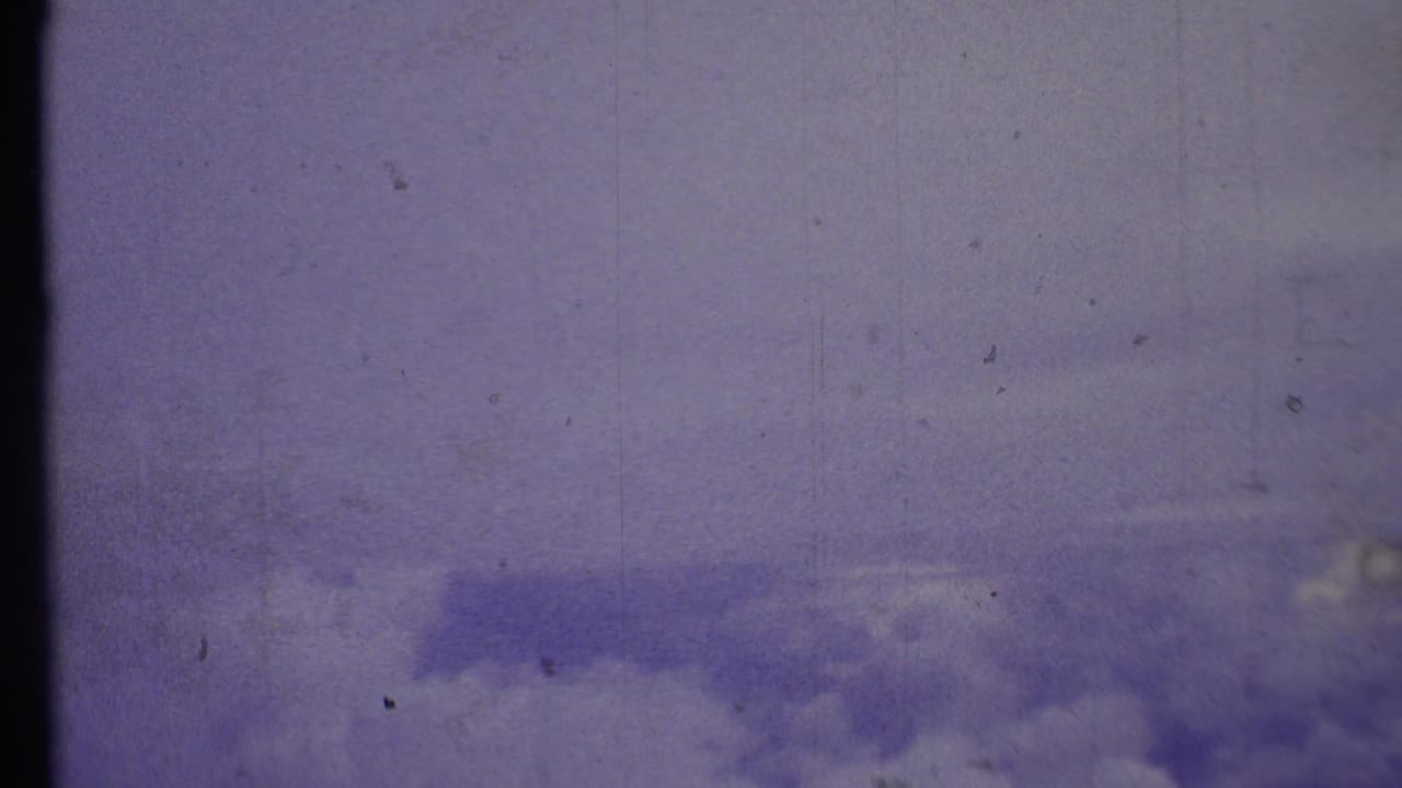 1972 8mm Grand Canyon-area home-movie frame showing a lavender-blue sky with soft clouds and film wear.