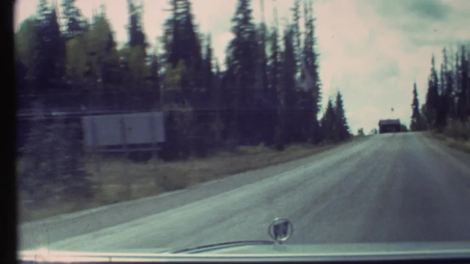 1972 8mm windshield view continuing along a forested Grand Canyon area road after the entrance approach.