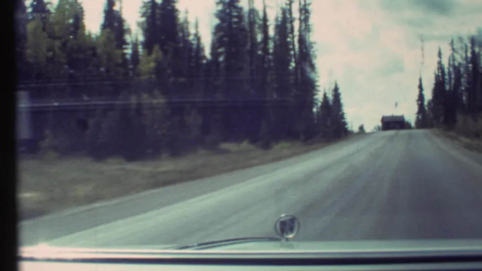 1972 8mm view through a car windshield on a forested mountain road near the Grand Canyon area.
