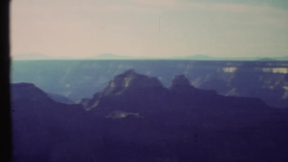 Grand Canyon panorama on 8mm film showing layered rock forms, broad distance, and a pale blue horizon.