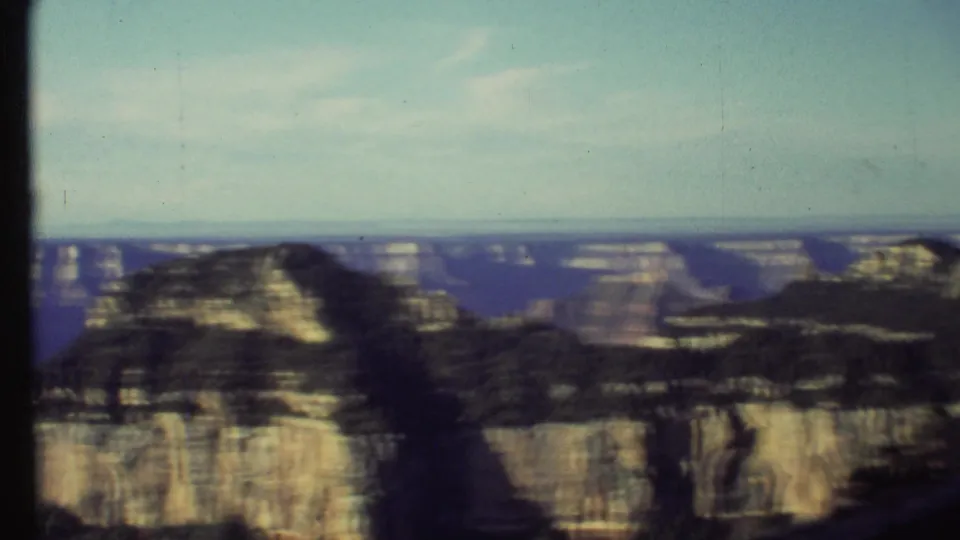 1972 8mm pan frame showing a sunlit Grand Canyon formation, softened by camera motion and film texture.