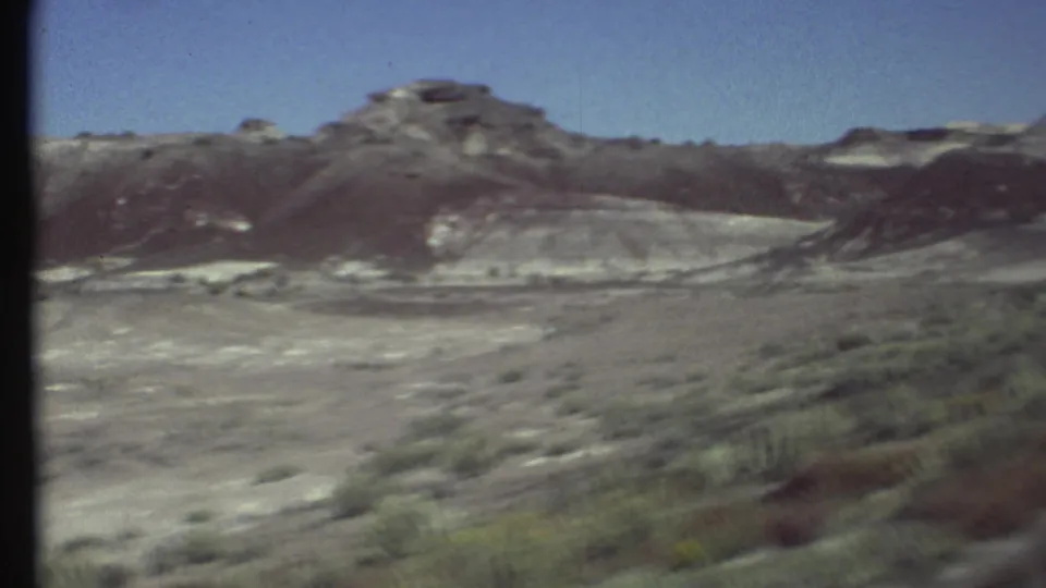 Steadier 1972 8mm view near Grand Canyon, Arizona, showing scrubland, pale slopes, and dark layered desert hills.