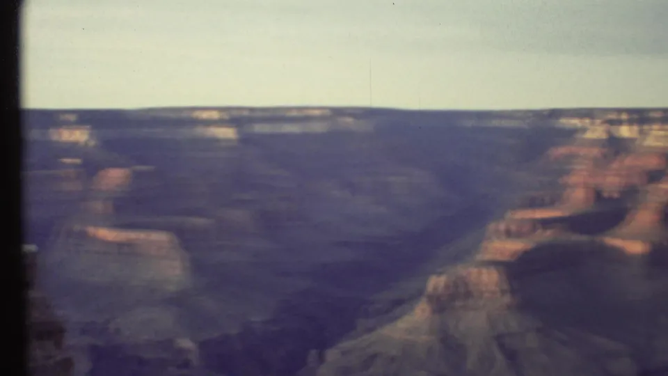 1972 Grand Canyon home-movie frame showing a blurred pan over red rock formations and deep canyon shadows.