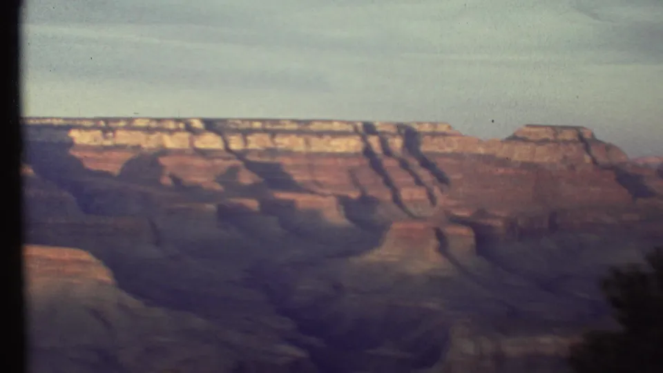 1972 8mm view of the Grand Canyon, showing layered canyon walls beneath a muted sky with dark gate edges from the film scan.