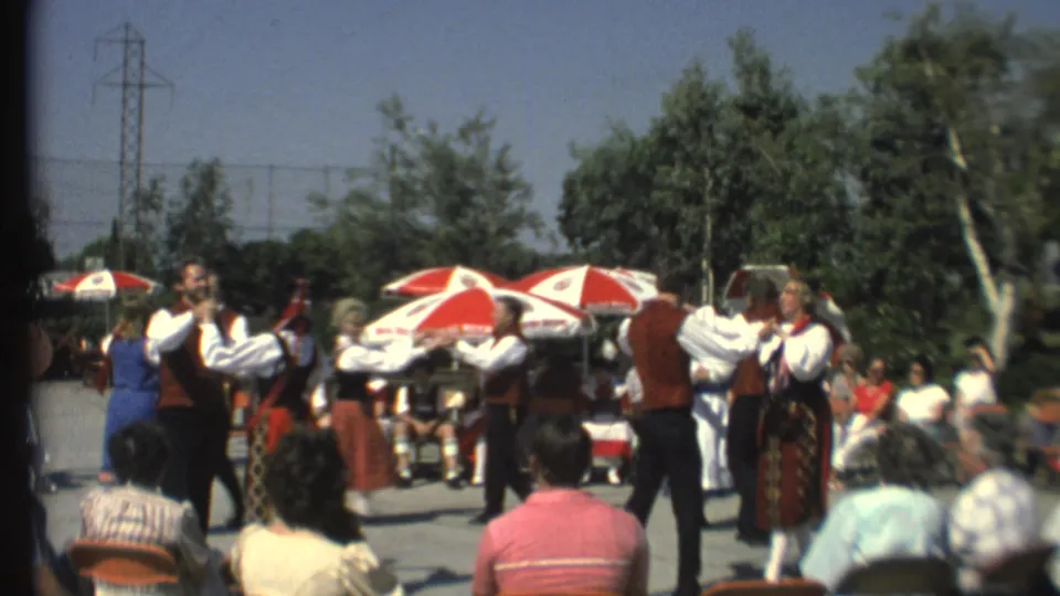 1972 8mm frame of costumed Norwegian dancers performing in a public area at Grand Canyon, with spectators nearby.