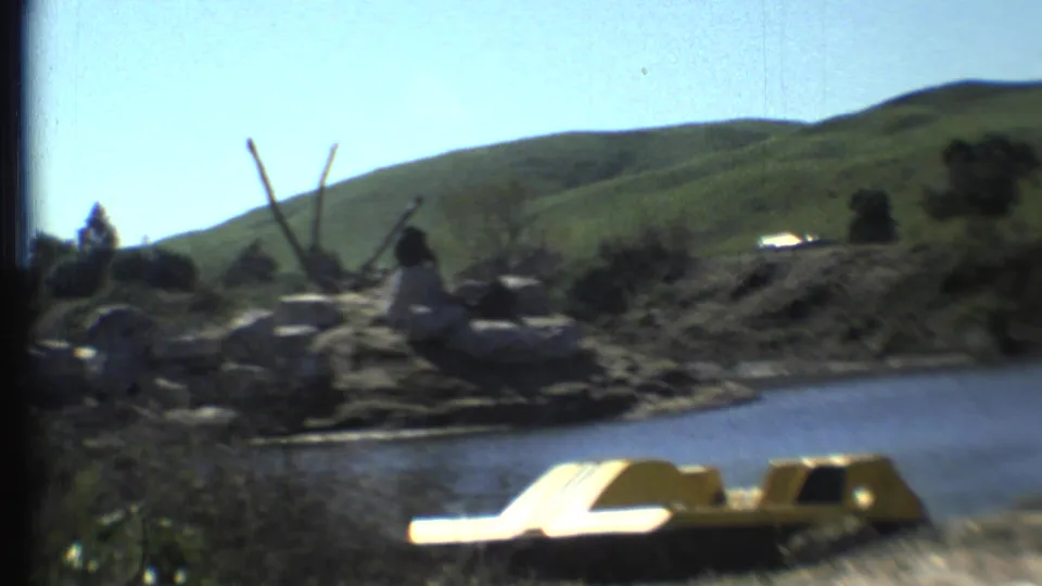 A tiger rests beside rocks and water in the supplied Grand Canyon, Arizona travel clip, with a yellow paddle boat in the foreground.