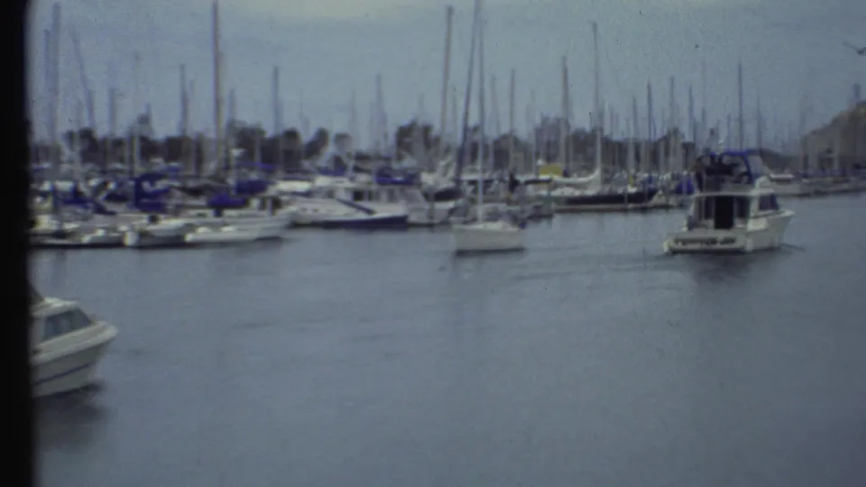 1972 Grand Canyon area marina view with sailboats docked close together and a white motorboat in the channel.