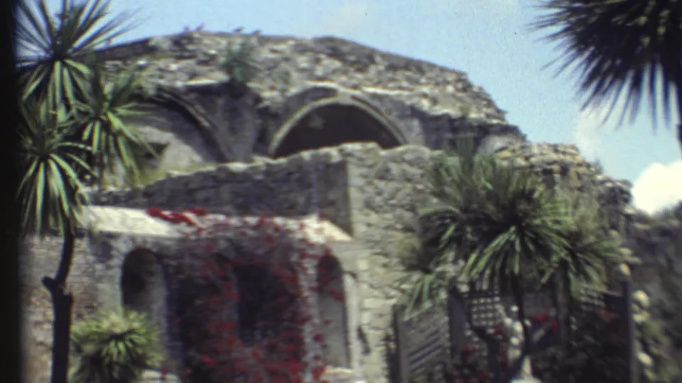 Grand Canyon, Arizona home-movie frame from 1972 with an old stone building, arched openings, and landscaped palms.