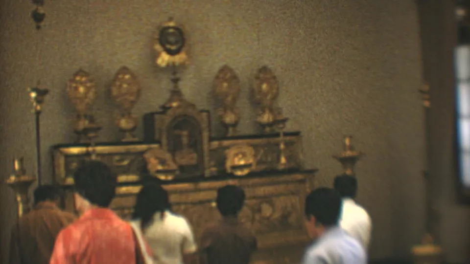 1973 Mexico City church interior with visitors or parishioners facing a gilded altar and a man passing near the camera.