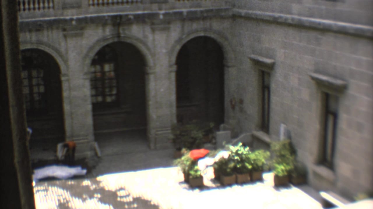 1973 Mexico City 8mm view of a church or historic building courtyard with stone arches, potted plants, and bright sunlight.