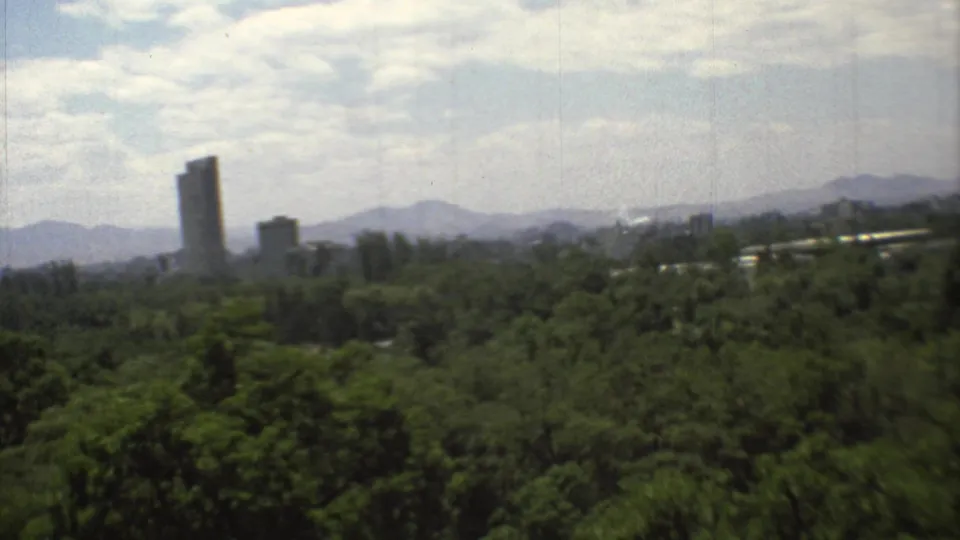 The final frame centers a tall distant tower above trees, with Mexico City buildings and mountains under a bright cloudy sky.