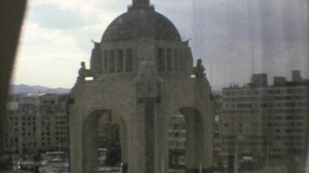 1973 Mexico City view of the Monumento a la Revolución with its dome and arches partly softened by glass reflection and film grain.