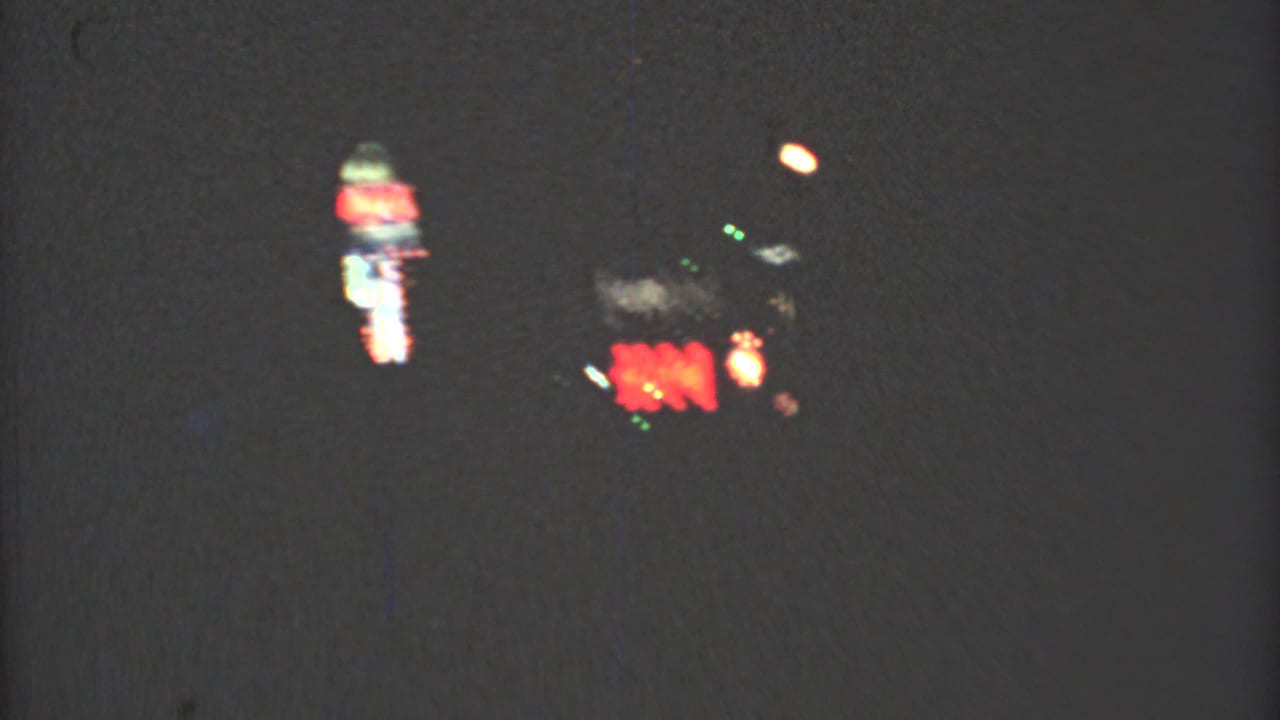 Late clip frame from the 1973 Mexico City night drive, with red and green lights smeared by low-light 8mm motion.