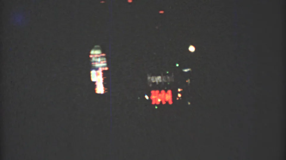 1973 Mexico City night footage showing blurred neon signs and street lights from a moving viewpoint.
