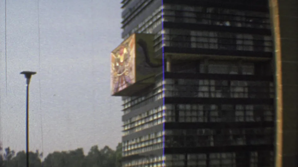 1973 Mexico City close framing of the dark banded building, decorative side projection, lawn edge and tall lamp post.
