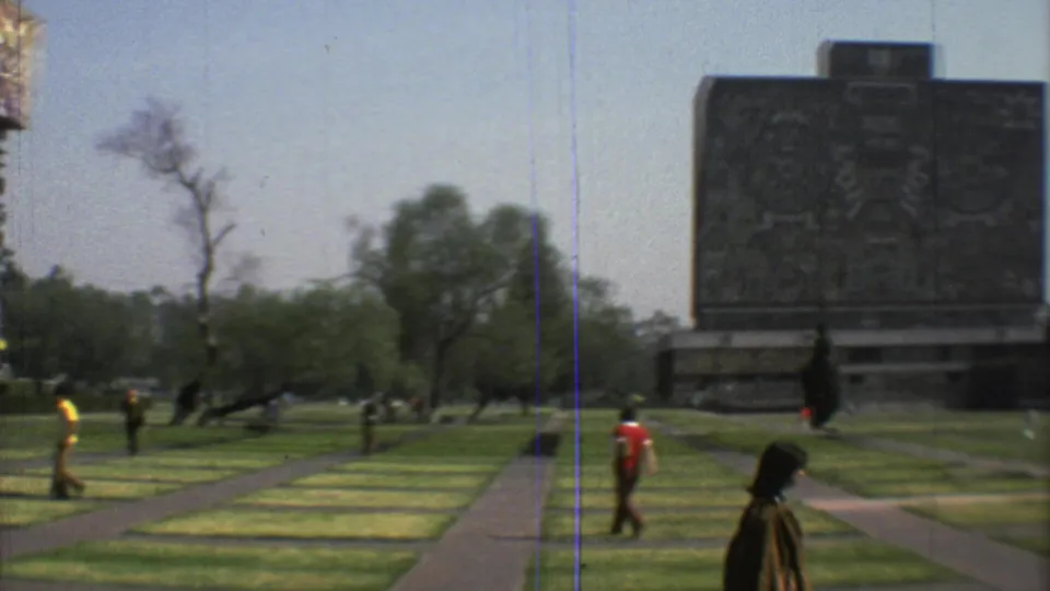 Mexico City park scene from 1973 with a large decorated wall panel, striped grass, paths, trees, and people walking through the grounds.