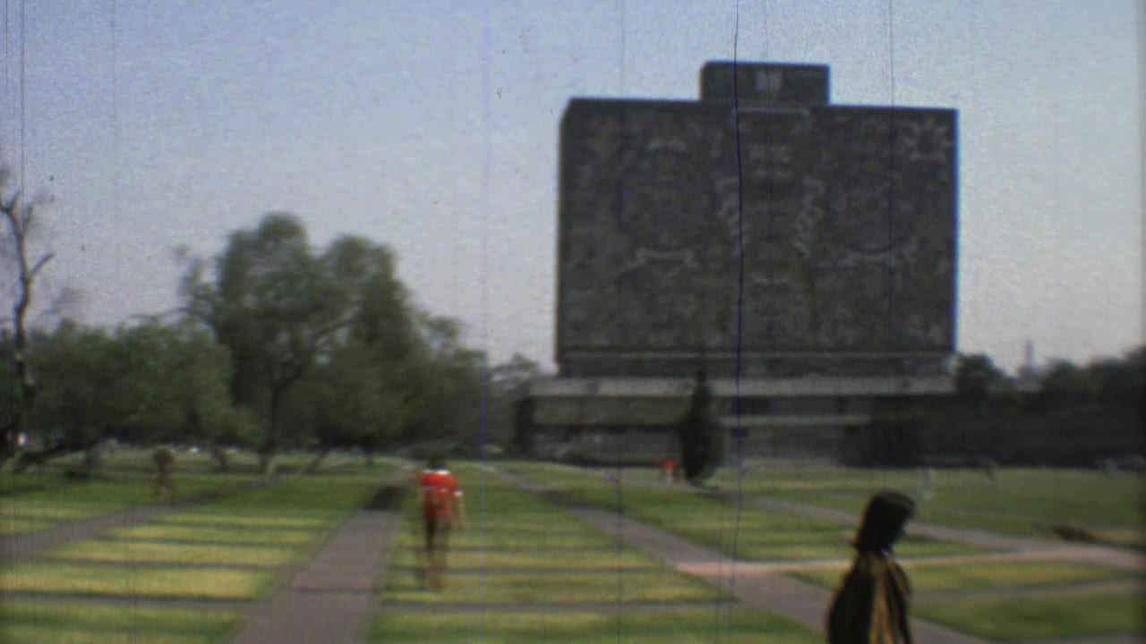 Large carved stone monument across a grassy park with pedestrians on paths.
