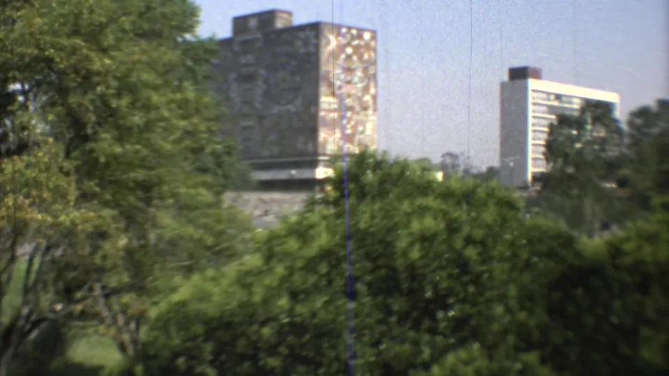 A wider 1973 Mexico City 8mm frame shows greenery in the foreground with a mural-like high-rise surface and pale modern building beyond.