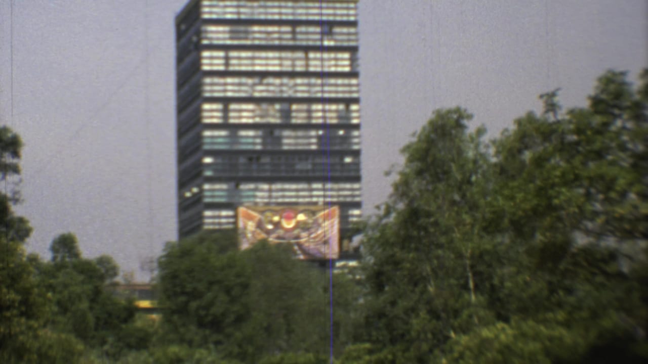 1973 Mexico City 8mm frame with a high-rise, a colorful facade artwork, and tall trees filling the foreground.