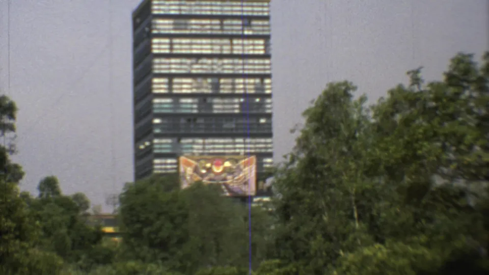1973 Mexico City 8mm frame with a high-rise, a colorful facade artwork, and tall trees filling the foreground.