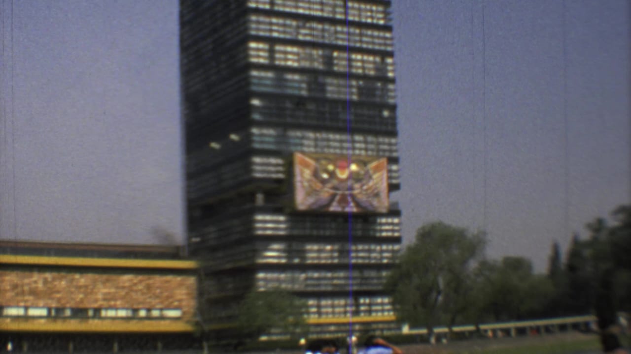 A wider 1973 Mexico City view shows the banner reduced in scale on the high-rise, with trees and open sky around it.