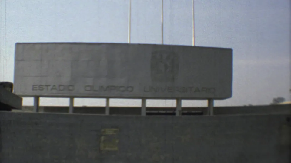 1973 Mexico City frame centered on the Estadio Olimpico Universitario sign mounted above a concrete stadium wall.