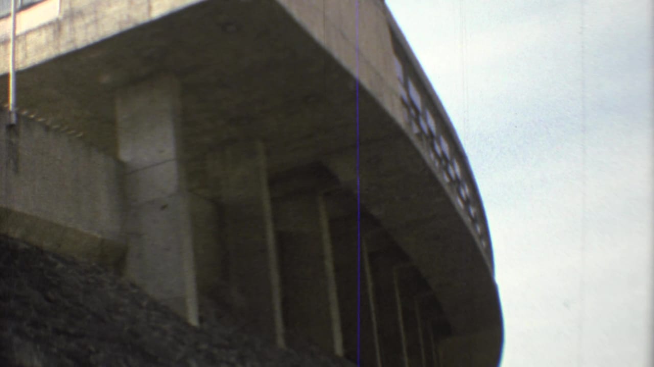 1973 Mexico City frame showing the underside of Estadio Olimpico Universitario's curved concrete stand with vertical supports.