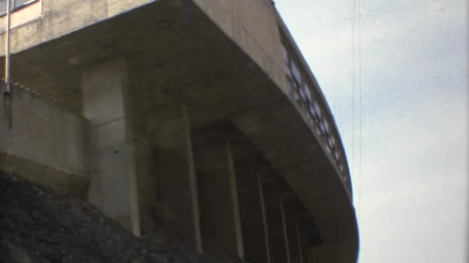 1973 Mexico City 8mm frame showing a low-angle view of a concrete overpass, its underside, pillars, and rough embankment.