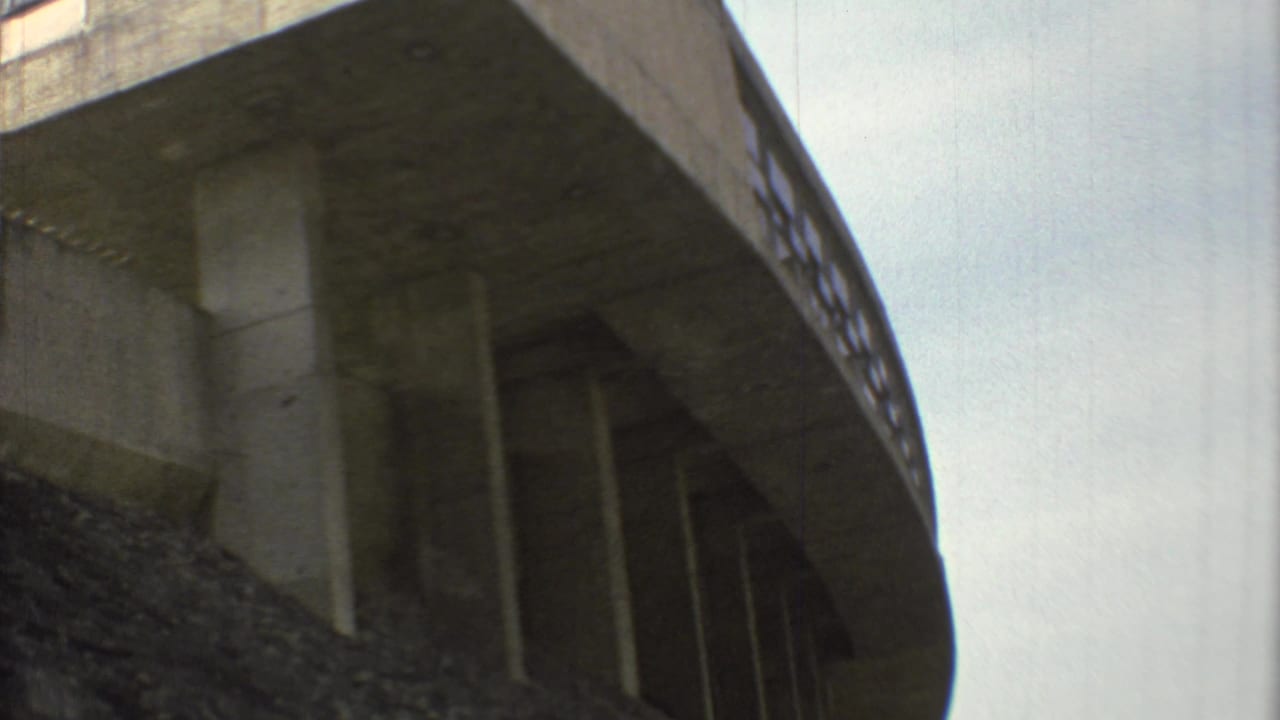 1973 Mexico City frame of the overpass from a similar low angle, emphasizing the heavy concrete deck and vertical supports.