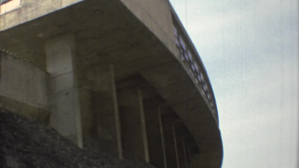 1973 Mexico City frame of the overpass from a similar low angle, emphasizing the heavy concrete deck and vertical supports.