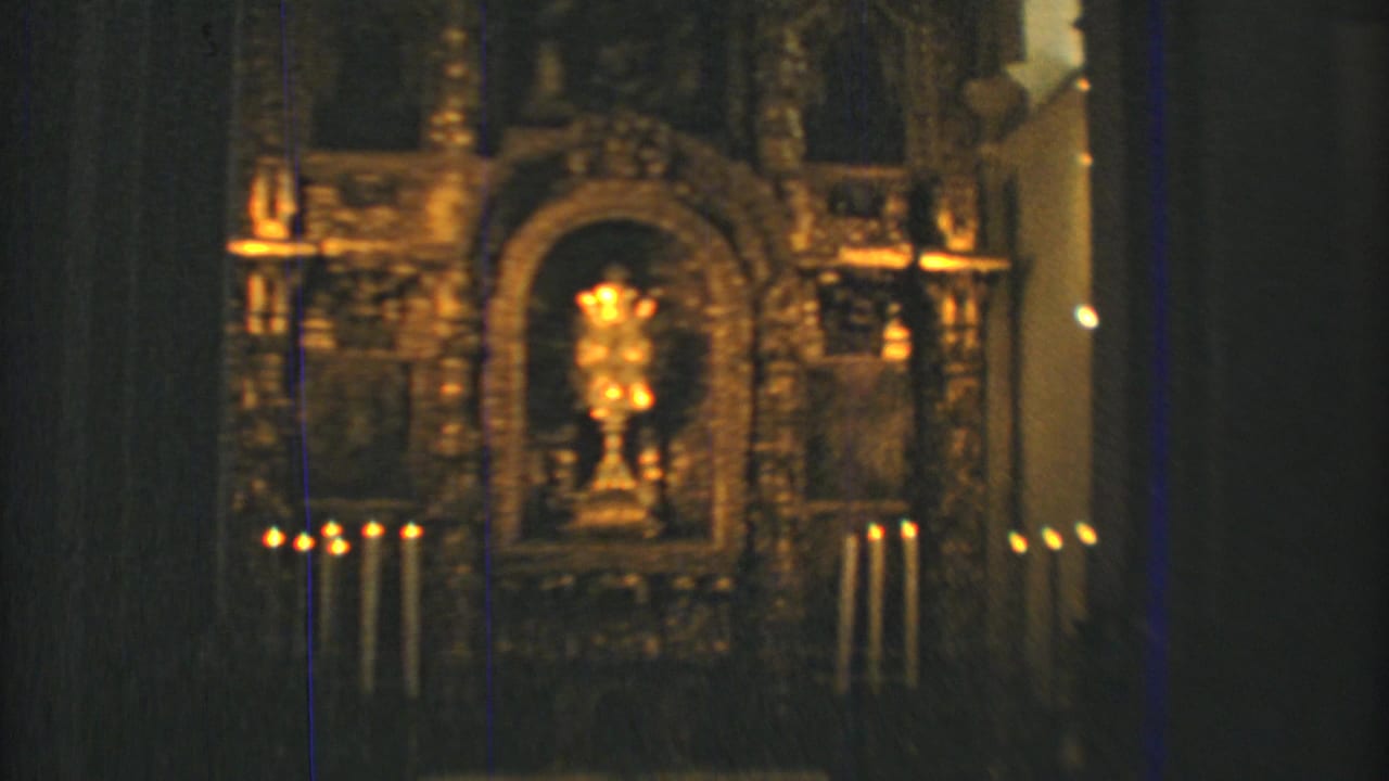 Candlelit church altar in Mexico City, filmed in warm low light on 8mm with a central gold-toned religious object.
