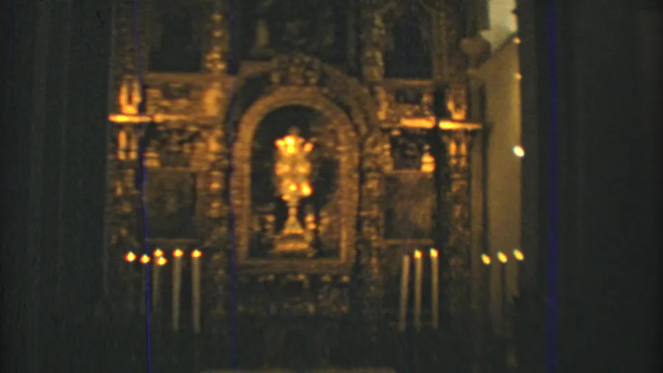 Candlelit church altar in Mexico City, filmed in warm low light on 8mm with a central gold-toned religious object.