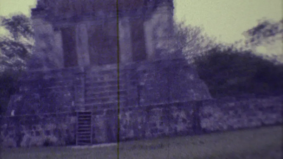 1973 8mm Yucatan frame with a closer look at the ruin's stepped stone base, dark doorway, and surrounding vegetation.