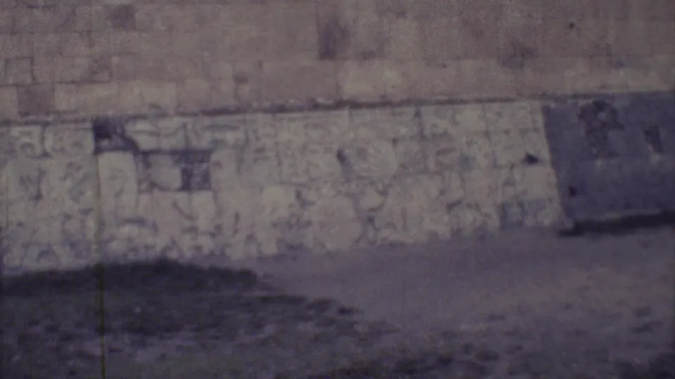 1973 Yucatan 8mm frame with carved masonry filling the view and a dark rectangular section in the wall.