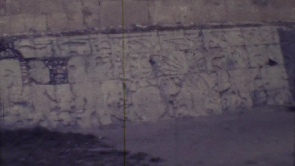Close 1973 Yucatan frame of carved wall reliefs, muted color, and visible 8mm film wear.