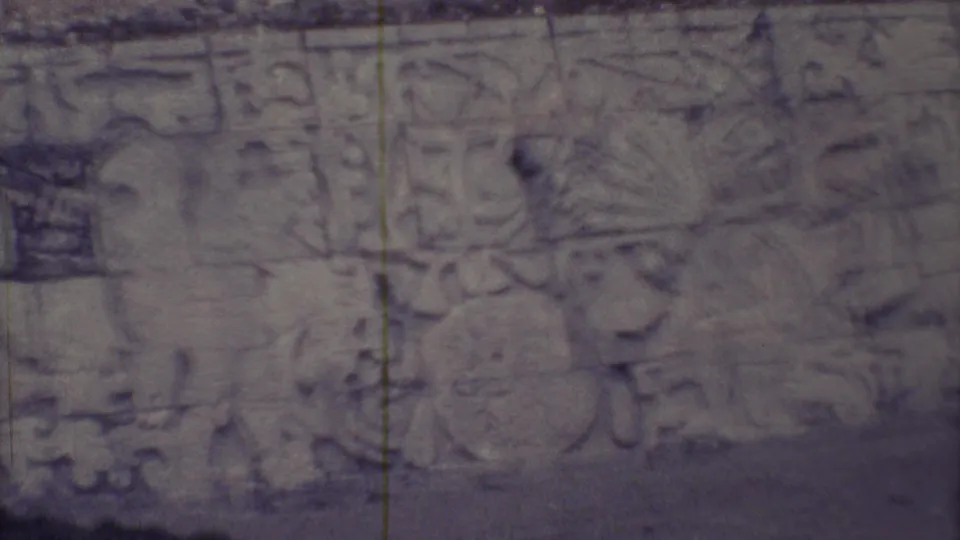 1973 Yucatan 8mm close-up of weathered Maya-style carved stone glyphs and relief forms on a wall surface.