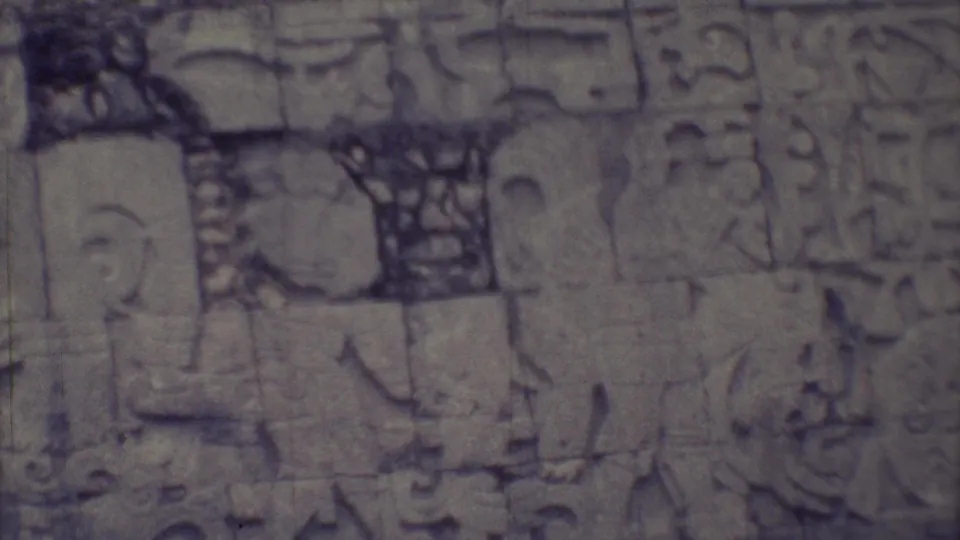 1973 Yucatan 8mm frame showing carved stone reliefs on a weathered wall, with soft focus and faded color.
