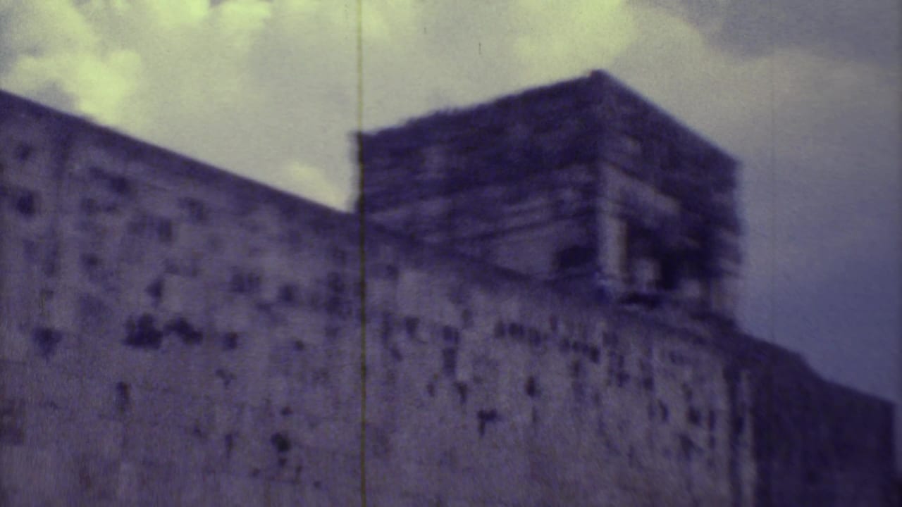 Weathered stone temple under a cloudy sky, seen in soft 8mm color.