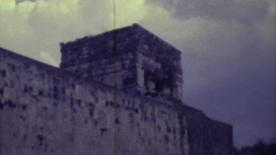A soft 8mm frame shows weathered stonework and an upper temple form at a Yucatan ruin site in 1973.